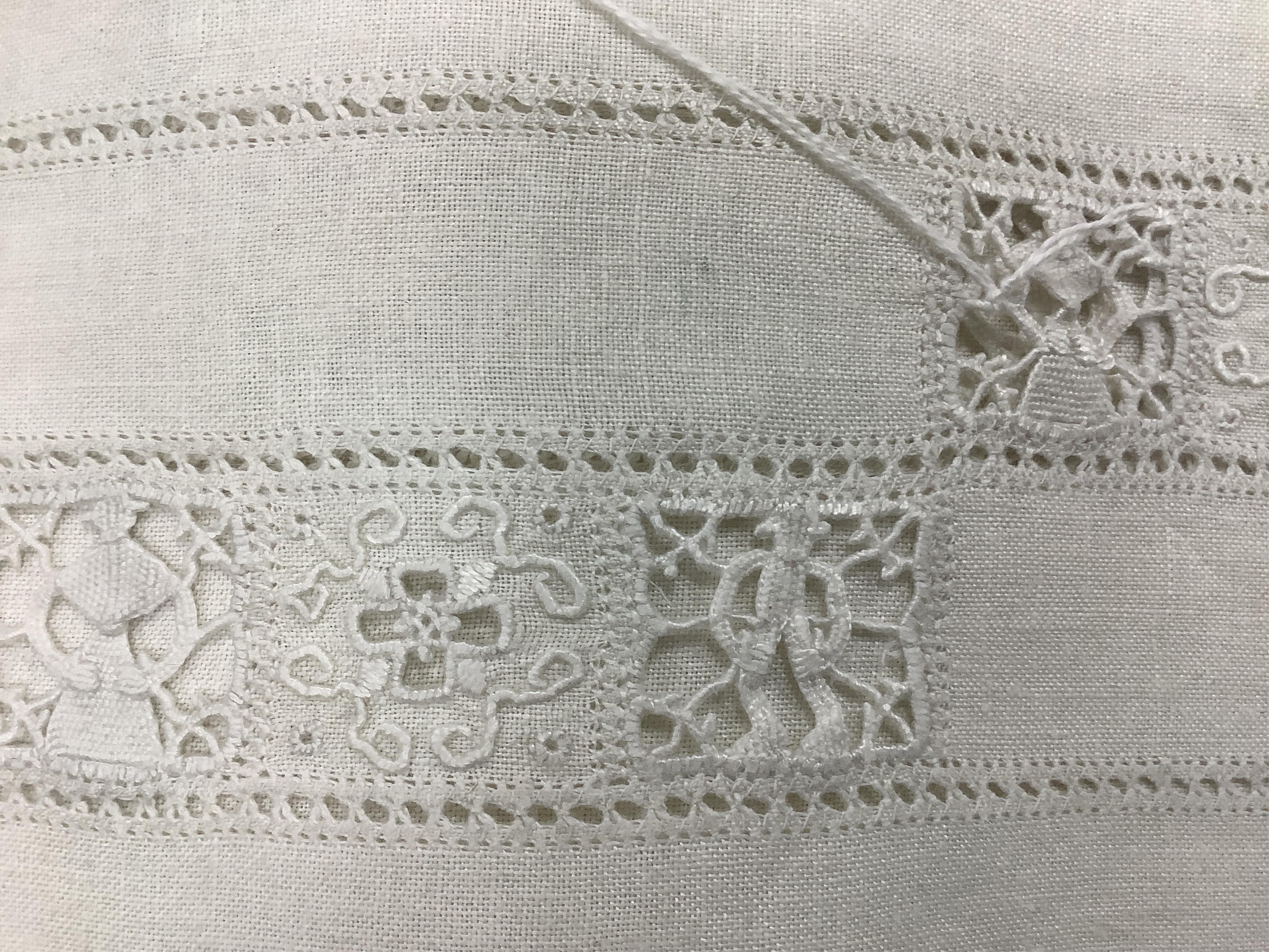 An Italian large linen drawn thread worked and embroidered table cloth, with small square needle lace insertions, 275cm long x 180cm wide. Condition - has a rust line, which maybe removed with rust remover. The cloth is